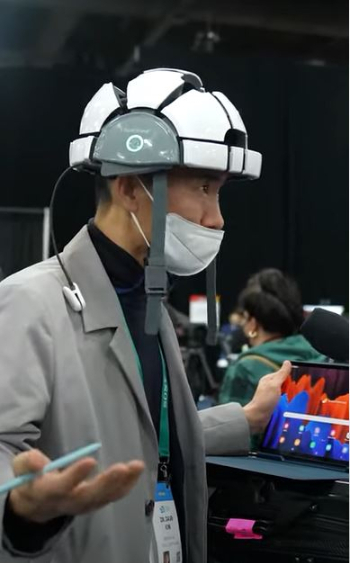 김대근 아이메디신 이사가 뇌파 측정기기 '아이싱크브레인'을 착용하고 로이터 취재진들과 인터뷰 중이다/사진=유튜브 Mrkeybrd 채널