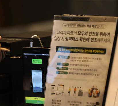 서울 시내 커피 매장에 한 시민이 큐알(QR) 코드 스캔과 방역패스 유효 상태를 체크하고 있다. /사진=뉴스1