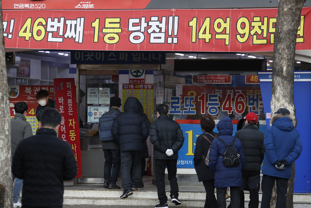(서울=뉴스1) 권현진 기자 = 28일 오전 서울 노원구의 복권판매점 앞에서 시민들이 복권을 사기 위해 줄을 서 있다. 올해로 발행 20주년을 맞은 로또 복권은 오는 29일 대망의 1000번째 추첨을 앞두고 있다. 회당 평균 500억~600억원이던 로또 판매 금액은 올해 들어 3주 연속 1000억 원을 훌쩍 넘었다. 신종 코로나바이러스 감염증(코로나19) 확산과 경기 불황으로 인한 불안 심리가 로또 구매 열풍으로 이어진 것으로 분석된다. 2022.1.28/뉴스1