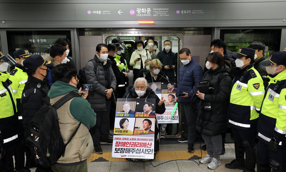 (서울=뉴스1) 장수영 기자 = 전국장애인차별철폐연대 구성원들이 14일 서울시 5호선 동대문역사문화공원에서 탑승해 광화문역까지 이동하며 장애인 대중교통 이동권 보장 촉구시위를 벌이고 있다. 2022.2.14/뉴스1