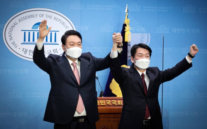 윤석열 국민의힘 대선 후보, 안철수 국민의당 대선 후보가 3일 서울 여의도 국회 소통관에서 단일화 기자회견을 마치고 손을 들어 올리고 있다. (공동취재사진) / 뉴시스
