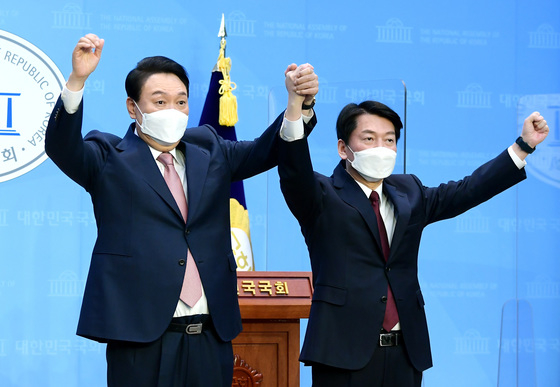  윤석열 국민의힘 대선 후보와 안철수 국민의당 대선 후보가 3일 오전 서울 여의도 국회에서 단일화 및 합당 관련 공동 기자회견을 마친 뒤 맞잡은 손을 들어보이고 있다.  /뉴스1  