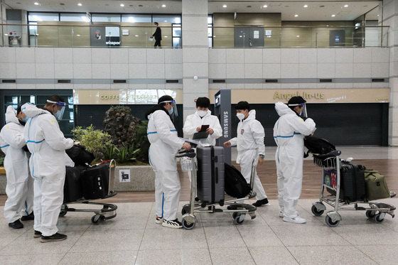 (인천공항=뉴스1) 조태형 기자 = 4일 오후 인천국제공항 터미널1에서 방호복을 입은 해외입국자들이 교통수단 이용을 위해 이동하고 있다.  정부는 국내 방역 시스템을 오미크론 대응체계로 전환함에 따라 이날 0시부터 해외에서 국내로 입국하는 사람들의 격리 기간도 10일에서 7일로 단축했다. 2022.2.4/뉴스1   