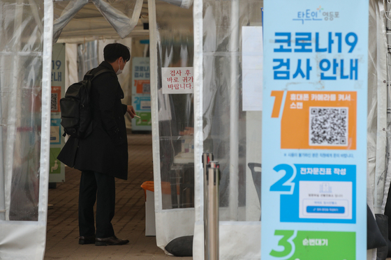 (서울=뉴스1) 안은나 기자 = 13일 서울 여의도공원 코로나19 임시 선별검사소에 PCR 검사를 받으러 온 시민이 신속항원검사 결과를 보여주고 있다.    이날 0시 기준 신규 확진자는 19만5419명으로 7주 만에 수요일 10만 명대를 기록했다. 위중증 환자는 1014명이며, 사망자는 184명으로 누적 2만 명을 넘어섰다. 2022.4.13/뉴스1  