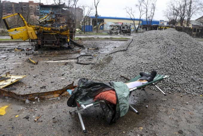 [마리우폴=AP/뉴시스] 13일(현지시간) 우크라이나 마리우폴에서 전투 중 파손된 한 차량 옆에 시신 한 구가 놓여 있다. 2022.04.14.