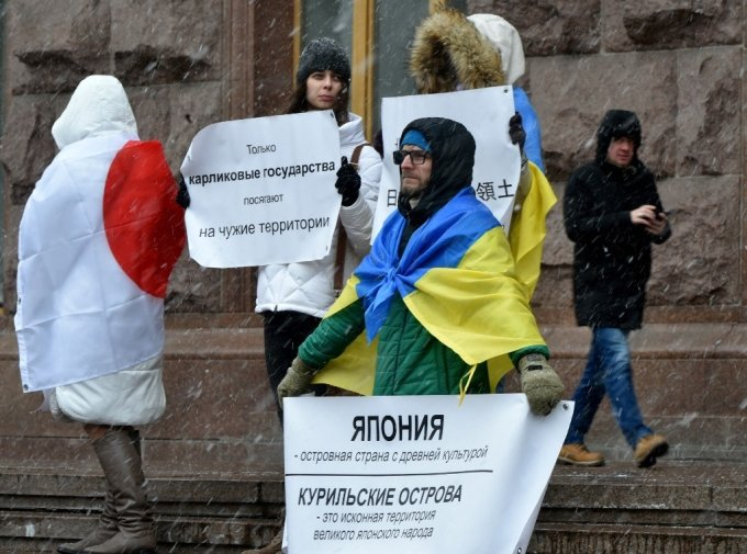 지난 2020년 2월 우크라이나 수도 키이우(키예프) 도심에서 국제활동가들이 러시아의 침략 성향을 비판하는 시위를 벌이고 있다. 우크라이나와 일본 국기를 덮어 쓴 이들은 "러시아는 자국 영토가 아닌데도 개의치 않는다"는 내용의 플래카드를 들고 있다. 우크라이나와 일본은 장기간 러시아와 영토권 분쟁을 벌여 왔다. /사진=AFP