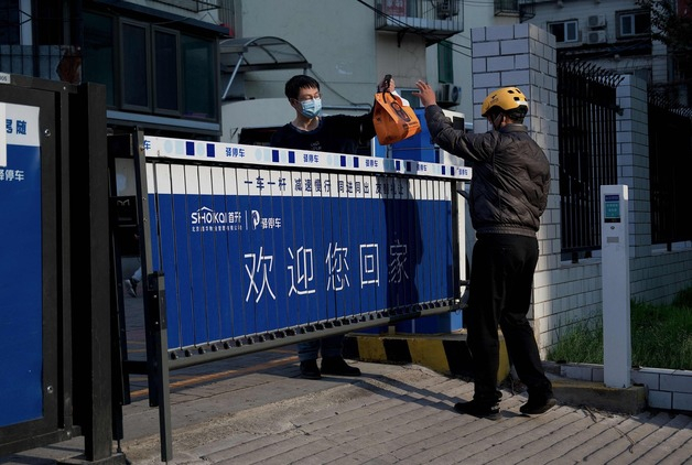 (베이징 AFP=뉴스1) 우동명 기자 = 4월28일(현지시간) 코로나19 봉쇄령이 내려진 중국 베이징 주거 지역에서 주민이 주문한 음식을 전달 받고 있다.  (C) AFP=뉴스1  