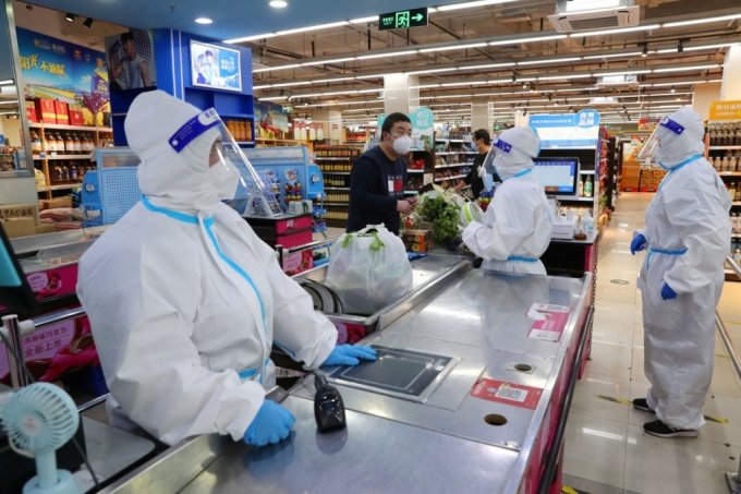 중국 상하이시가 유입 인원 제한을 전제로 일부 상업시설의 영업 재개 결정을 내렸다. 사진은 문을 연 한 슈퍼마켓. 직원들이 방호복을 입고 손님을 응대하고 있다. /ⓒ 로이터=뉴스1 