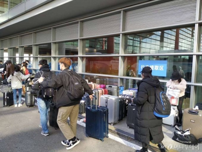 중국 베이징 서우두(首都) 공항에 도착한 한국인 승객들이 베이징 정부가 제공하는 차량을 타기 위해 이동하고 있다.