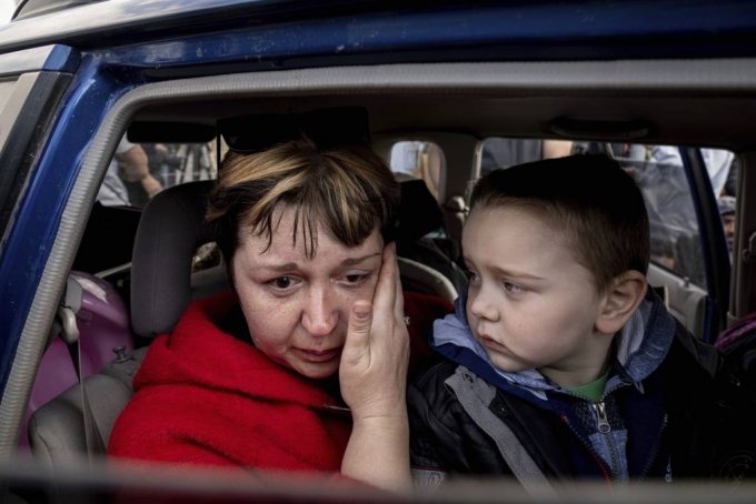 5월 2일(현지시간) 우크라이나 자포리자의 난민 센터에 도착한 한 피난민 여성이 손자가 걱정스레 바라보는 가운데 울먹이고 있다. /AP=뉴시스