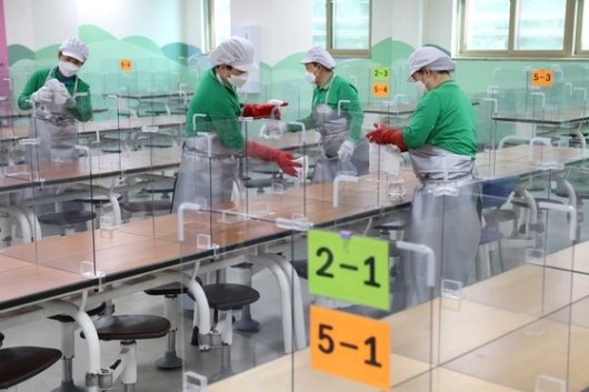 서울 마포구 성원초등학교 급식실에서 관계자들이 비말 차단 가림막을 닦고 있다. 사진=뉴스1