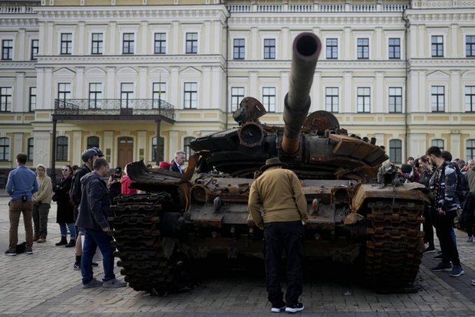 [키이우=AP/뉴시스] 23일(현지시간) 우크라이나 키이우 시내에서 시민들이 전쟁의 상징으로 광장에 놓인 파괴된 러시아군 전차를 살펴보고 있다. 2022.05.24.