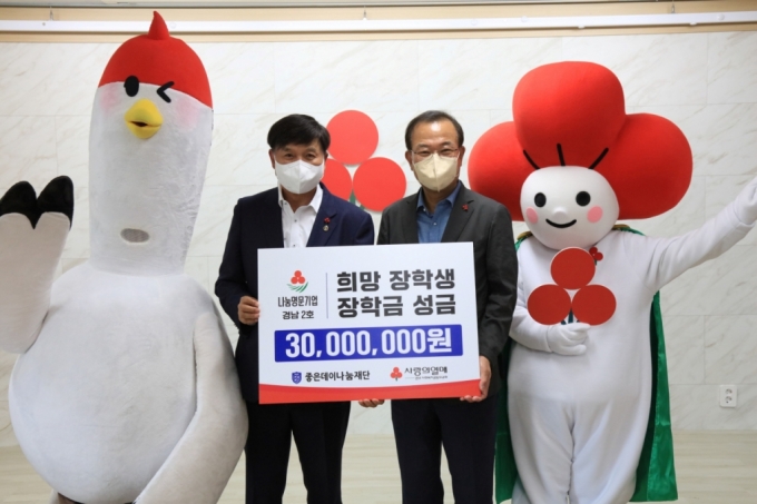 최재호 무학 회장(왼쪽)이 25일 강기철 경남사회복지공동모금회 회장에게 희망장학생 장학금을 전달하고 있다./사진제공=무학