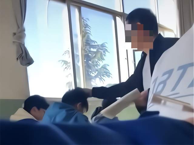 지난 10일 중국 원난성 자오퉁시의 한 중학교 교사가 조는 남학생의 머리채를 잡고 흔들고 있다/사진=신화통신