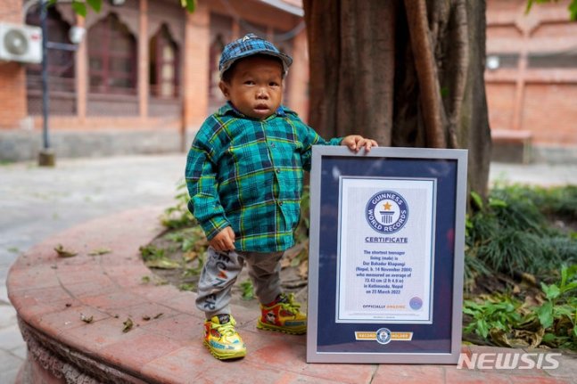 24일(현지시각) 네팔 카트만두에서 신장 73.43㎝로 세계에서 가장 작은 청소년으로 인정받은 도르 바하두르 카판지가 기네스 세계 기록 인증서와 함께 자세를 취하고 있다. /AP=뉴시스