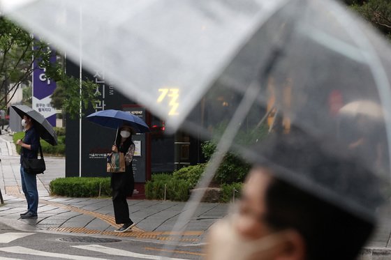 (서울=뉴스1) 조태형 기자 = 소나기가 내린 18일 오전 서울 시내에서 시민들이 우산을 쓴 채 출근하고 있다. 2022.5.18/뉴스1  