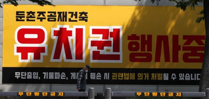 서울시와 국토부가 공사 중단 사태를 빚고 있는 둔촌주공 재건축 아파트 사업장에 대한 실태 점검에 나선다. 23일 오후 멈춰선 서울 강동구 둔촌주공 아파트 현장에 '유치권 행사중'이라는 문구가 보이고 있다. 2022.05.23.