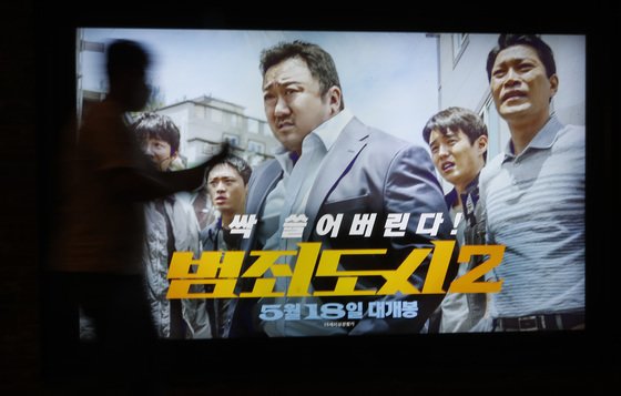 지난 7일 서울 CGV용산아이파크몰에서 ‘범죄도시2’ 포스터 앞으로 시민이 지나가고 있다. /사진=뉴스1