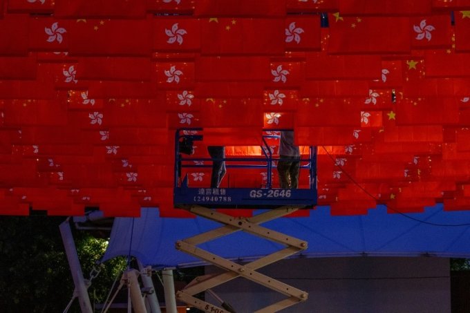 7월 1일 홍콩 주권 반환 25주년 기념식을 앞두고 홍콩 근로자가 웡타이신(Wong Tai Sin) 지구에 설치된 중국과 홍콩 국기에 조명을 설치하고 있다. /AFPBBNews=뉴스1