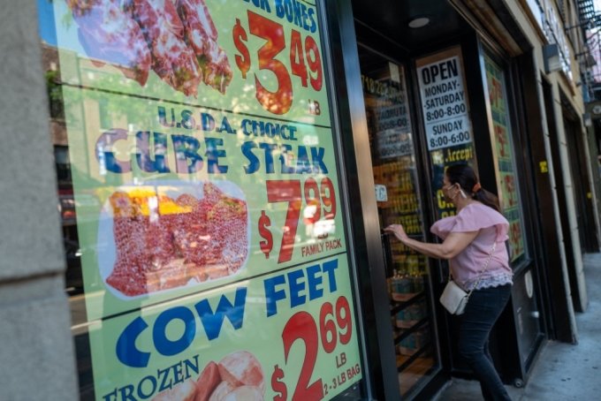지난 15일 한 소비자가 미국 뉴욕시 브루클린 플랫부시의 번화가에 있는 식료품점으로 들어가고 있다. 가게 외부에 육류의 가격이 표시돼 있다. 미국은 40년래 최악의 인플레이션(화폐가치 하락에 따른 물가상승)을 겪고 있다./AFPBBNews=뉴스1