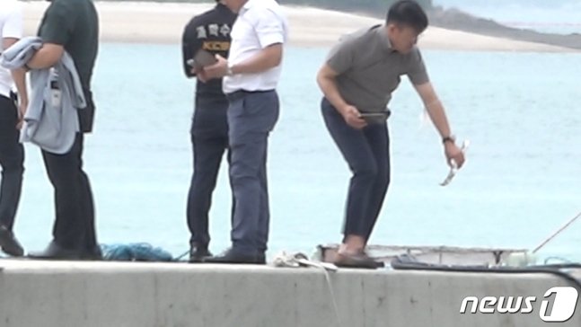 경찰이 완도 송곡항 인근 바다에서 건저올린 아우디 승용차 부품 일부를 확인하고 있다. (C) 뉴스1