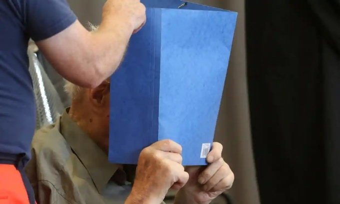나치 전범 요제프 쉬츠가 판결을 받기 위해 독일 브란덴부르크주 노이루핀 법정에 도착하면서 얼굴을 가리고 있다. /AFP=뉴스1