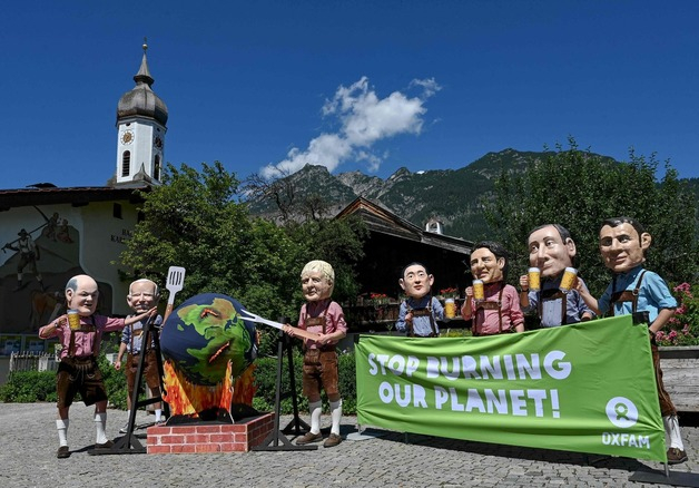 (가르미슈파르텐키르헨 AFP=뉴스1) 우동명 기자 = 26일(현지시간) 독일 바이에른 가르미슈파르텐키르헨에서 옥스팜이 G7 정상들의 모형 앞에 "우리 행성을 불태우는 것을 멈추라"는 현수막을 설치하며 시위를 하고 있다.  (C) AFP=뉴스1  