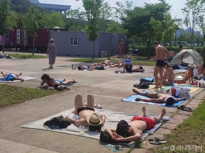 3일 오후 서울 영등포구 여의도 한강수영장에서 방문객들이 태닝을 즐기고 있다. /사진=정세진 기자