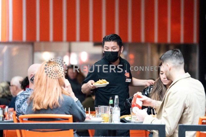 A waiter serves food at a restaurant near Times Square in New York City, U.S., December 16, 2021. REUTERS/Jeenah Moon/File Photo/사진=로이터=뉴스1