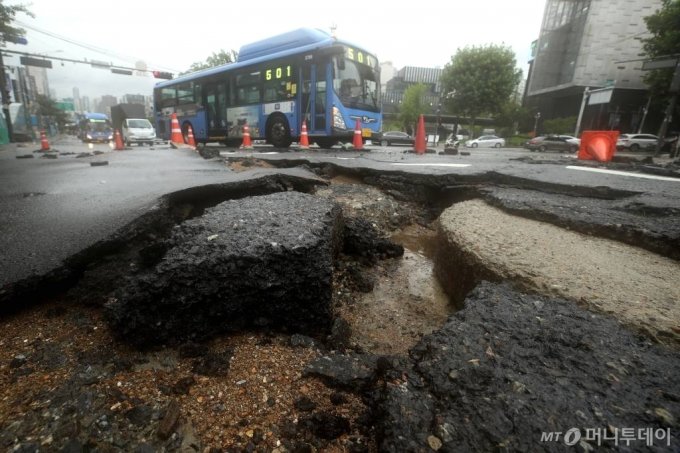 밤사이 서울 등 중부지방에 기록적 폭우가 내린 가운데 9일 서울 숭실대입구역 인근 도로가 파손돼 있다. /사진=김휘선 기자 hwijpg@