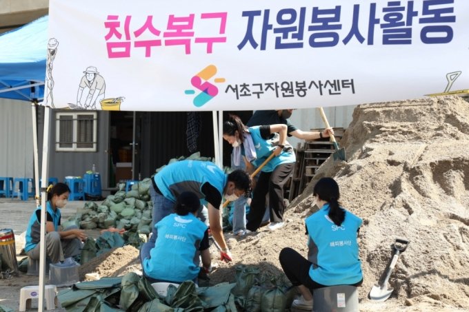 SPC그룹 임직원들이 지난 12일 서울 서초구 반포종합운동장에서 하천 범람 방지를 위한 모래주머니를 제작하고 있다./사진제공=SPC그룹