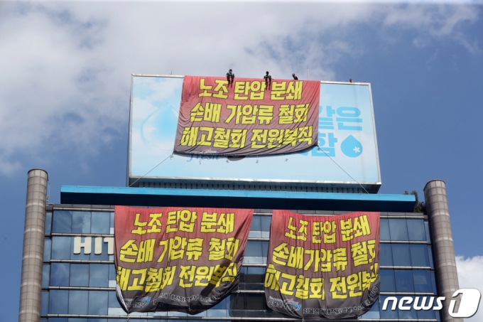 (서울=뉴스1) 황기선 기자 = 민주노총 공공운수노조 화물연대 조합원들이 16일 오후 서울 강남구 하이트진로 본사 옥상에서 고공농성을 하고 있다. 조합원들은 이날 조합원들의 복직과 손해배상 청구 철회 등을 요구하며 본사 옥상에서 점거 농성을 시작한다고 밝혔다. 2022.8.16/뉴스1 Copyright (C) 뉴스1. All rights reserved. 무단 전재 및 재배포 금지.
