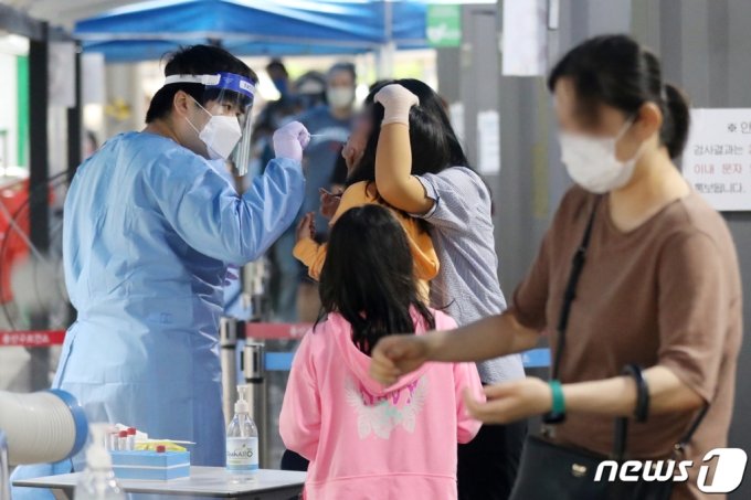 (서울=뉴스1)  = 8일 오전 서울 용산구 보건소에 마련된 신종 코로나바이러스 감염증(코로나19) 선별검사소에서 한 어린이가 검체 검사를 받고 있다. 