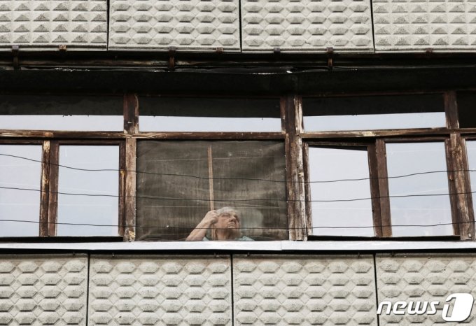 (크라마토르스크 로이터=뉴스1) 손승환 기자 = 13일(현지시간) 우크라이나 도네츠크주 크라마토르스크에서 한 여성이 자택 창문을 통해 밖을 내다보고 있다. 크르마토르스크는 우크라이나군의 지역 본부가 위치한 전략적 요충지다.   ⓒ 로이터=뉴스1  Copyright (C) 뉴스1. All rights reserved. 무단 전재 및 재배포 금지.