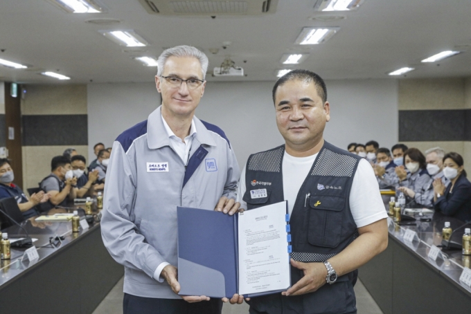 한국GM 노사가 2022년 임단협 교섭 합의안에 대한 조인식을 갖고 기념 촬영을 하고있다.좌측부터 로베르토 렘펠 한국GM 사장, 김준오 금속노조 한국GM지부 지부장)/사진제공=한국GM