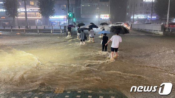 지난 8월 8일 밤 서울 관악구 도림천이 범람, 주변을 지나는 시민들이 발걸음을 재촉하고 있다/사진=뉴스1