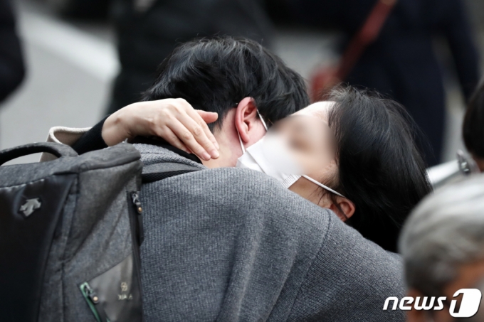 2022학년도 대학수학능력시험일인 지난해 11월 18일 오후 서울 서초구 서초고등학교에서 시험을 마친 한 수험생이 어머니의 품에 안겨 있다./사진=뉴스1