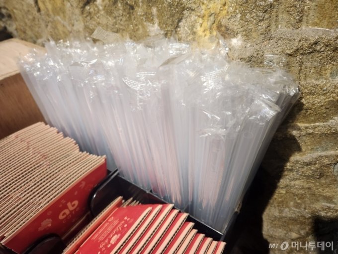 일회용품 사용 제한이 확대된 24일 오후 1시쯤 서울 강남구의 한 카페 안에 비닐 포장된 플라스틱 빨대가 쌓여 있다./사진=박수현 기자