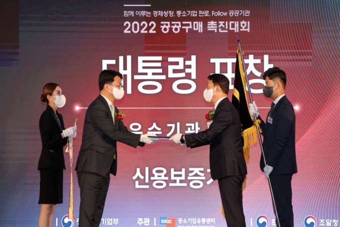 김충배 신용보증기금 전무이사(사진 오른쪽 2번째)가 지난 24일 '2022 공공구매촉진대회'에서 조주현 중소벤처기업부 차관(사진 왼쪽 2번째)으로부터 공공구매 유공 대통령 표창을 수여받고 있다./사진제공=신보