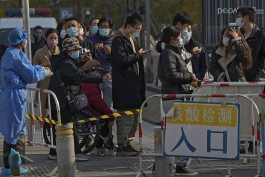 중국 베이징의 코로나19 검사소에서 검사를 받으려는 주민들이 스마트폰을 이용해 건강 점검 QR 코드를 읽고 있다. 베이징=AP/뉴시스