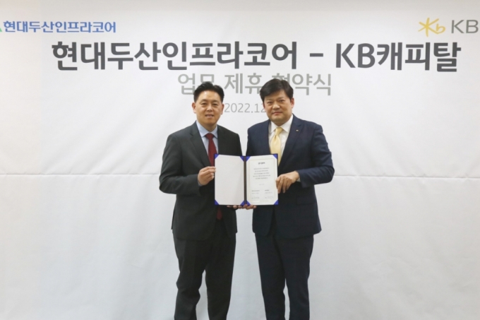김인환 KB캐피탈 본부장(사진 오른쪽)과 송희준 현대두산인프라코어 영업부문장이 서울 서초동 KB캐피탈 본사에서 업무협약을 체결한 뒤 기념사진을 촬영하고 있다./사진제공=KB캐피탈