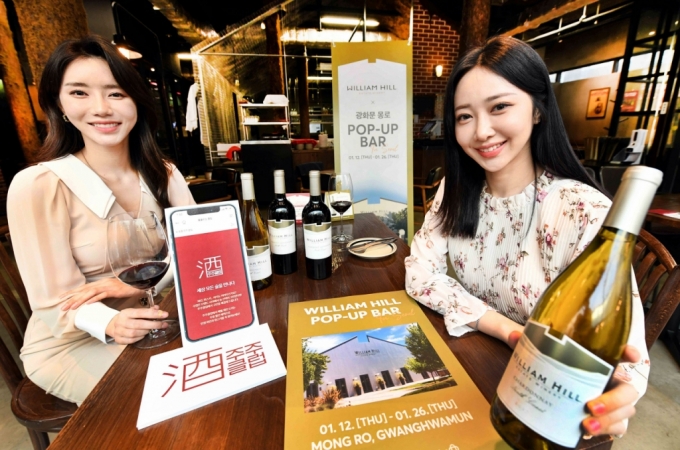 모델들이 서울시 중구 '광화문 몽로'에 운영 중인 '홈플러스 X 윌리엄힐 팝업바'에서 홈플러스가 단독 론칭한 '윌리엄 힐 노스 코스트' 와인을 선보이고 있다. 홈플러스는 멤버십 회원을 대상으로 운영 중인 '홈플러스 클럽' 중 와인클럽과 맥덕클럽을 통합하고 위스키까지 더해 모든 주종의 술로 범위를 넓힌 '주주클럽'을 론칭하고 오는 25일까지 주주클럽 회원을 대상으로 윌리엄 힐 와인 10% 할인쿠폰을 지급한다./사진= 홈플러스 제공