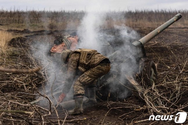 우크라이나 바흐무트에서 병사가 러시아 군 진지를 향해 120 mm 박격포를 발사하면서 포탄을 재장전하고 있다./ⓒ AFP=뉴스1