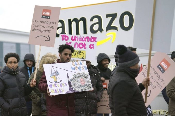 [코번트리=AP/뉴시스] 25일(현지시간) 영국 코번트리에 있는 아마존 물류센터 앞에서 아마존 근로자들이 임금 분쟁으로 영국 아마존 사상 첫 파업을 벌여 이들이 속한 GMB 노조원들이 시위에 참여하고 있다. 2023.01.26.