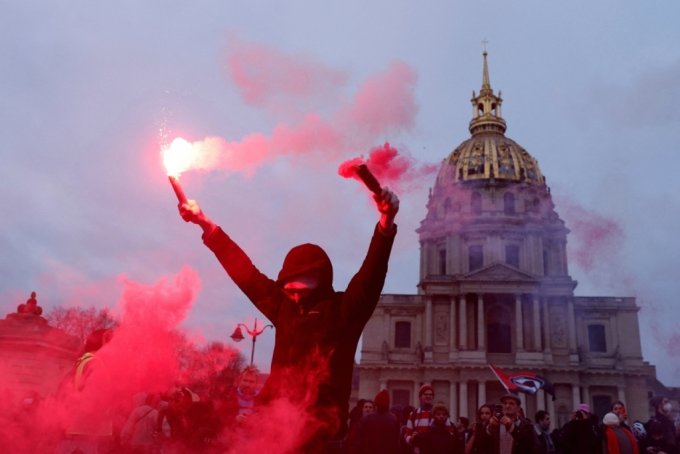 31일(현지시간) 프랑스 파리에서 연금 개혁안 반대 시위 참가자가 붉은 조명탄을 들고 있다./로이터=뉴스1