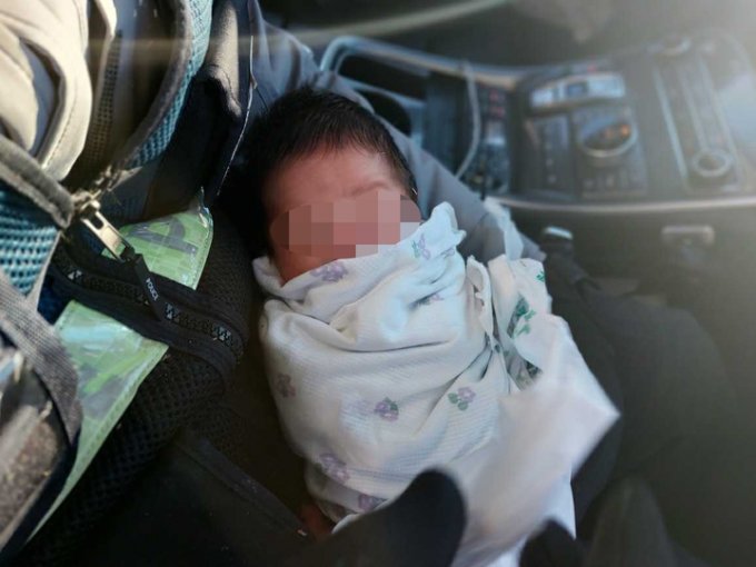 지난달 20일 오후 갓난아이를 발견한 경찰관이 순찰차에서 아이를 안고 있다. /사진제공=강원도소방본부./사진=뉴시스.