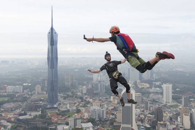 [쿠알라룸푸르=AP/뉴시스] 3일(현지시간) 말레이시아 쿠알라룸푸르에서 쿠알라룸푸르(KL) 타워 국제 점프대회가 열려 베이스(BASE) 점핑 선수들이 뛰어내리고 있다. &#039;BASE&#039;는 건물(Buildings), 안테나(Antennas), 교량(Spans), 지구(Earth)를 나타내는 것으로 지상의 높은 건물이나 절벽 등에서 낙하산으로 강하하는 매우 위험한 익스트림 스포츠다. 2023.02.03.