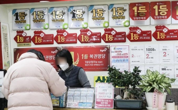 **해당 사진은 기사와 직접적인 연관 없음. 지난 12일 서울 시내 한 복권 판매점에서 한 시민이 복권을 구매하고 있다./사진=뉴스1