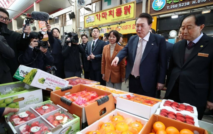 [청주=뉴시스] 전신 기자 = 윤석열 대통령이 14일 충북 청주 육거리종합시장을 방문해 청과물 가게에서 과일을 살펴보고 있다. 2023.02.14.