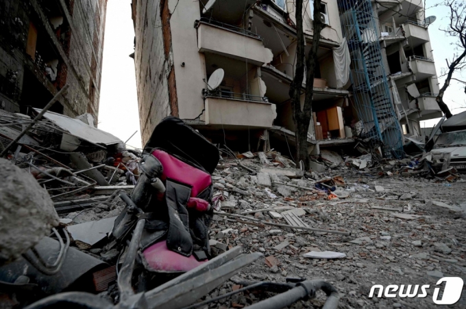 12일(현지시간) 규모 7.8의 지진이 강타한 튀르키예 카라만마라슈의 붕괴된 건물 잔해 사이에서 부서진 유모차가 보인다.  /AFPBBNews=뉴스1
